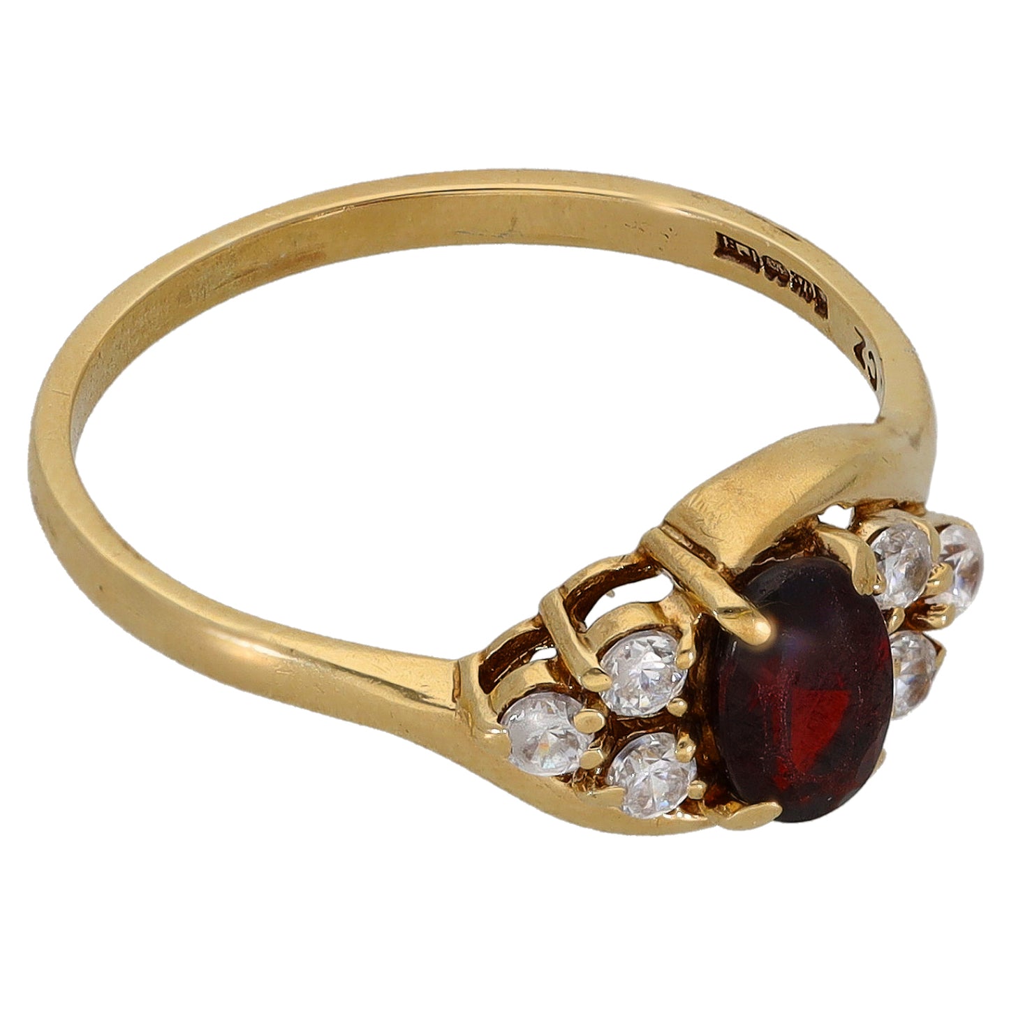 Gold cocktail ring with oval red garnet flanked by clear CZ stones, raised bezel
