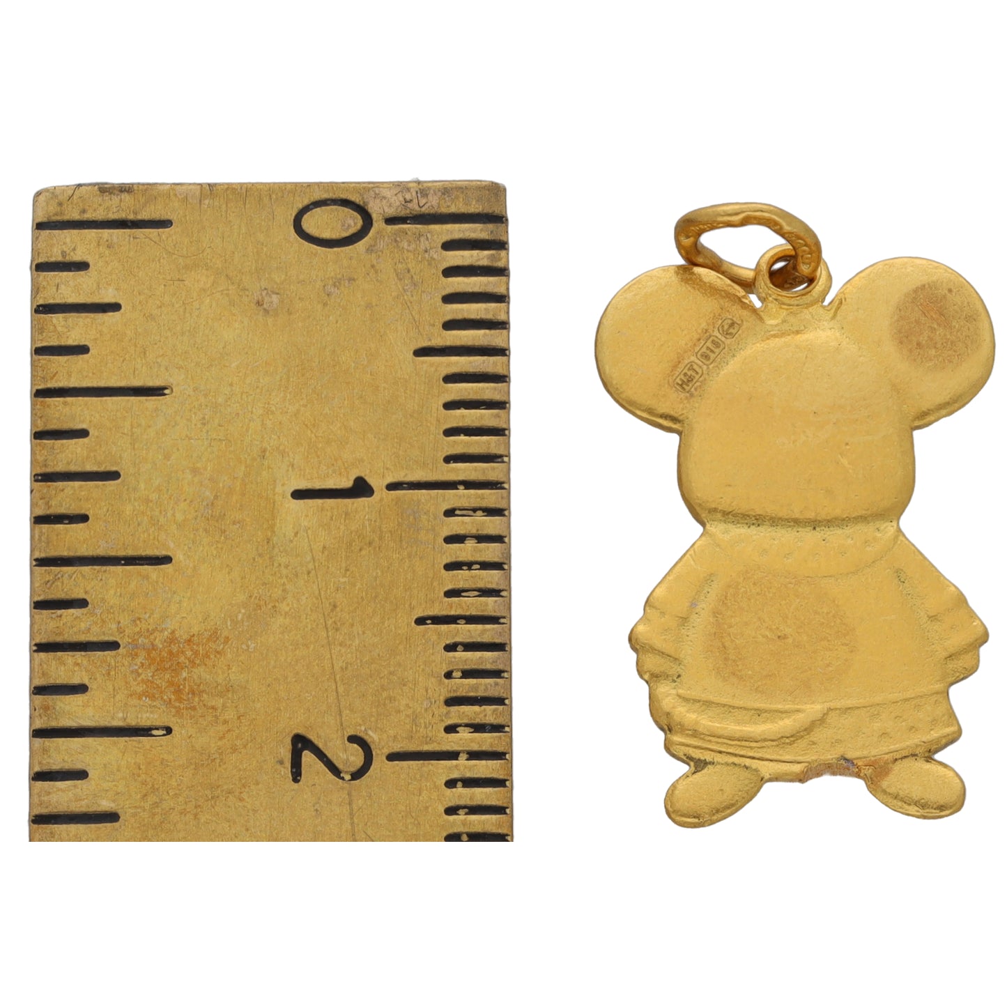 Gold clown/doll character pendant next to ruler for size scale