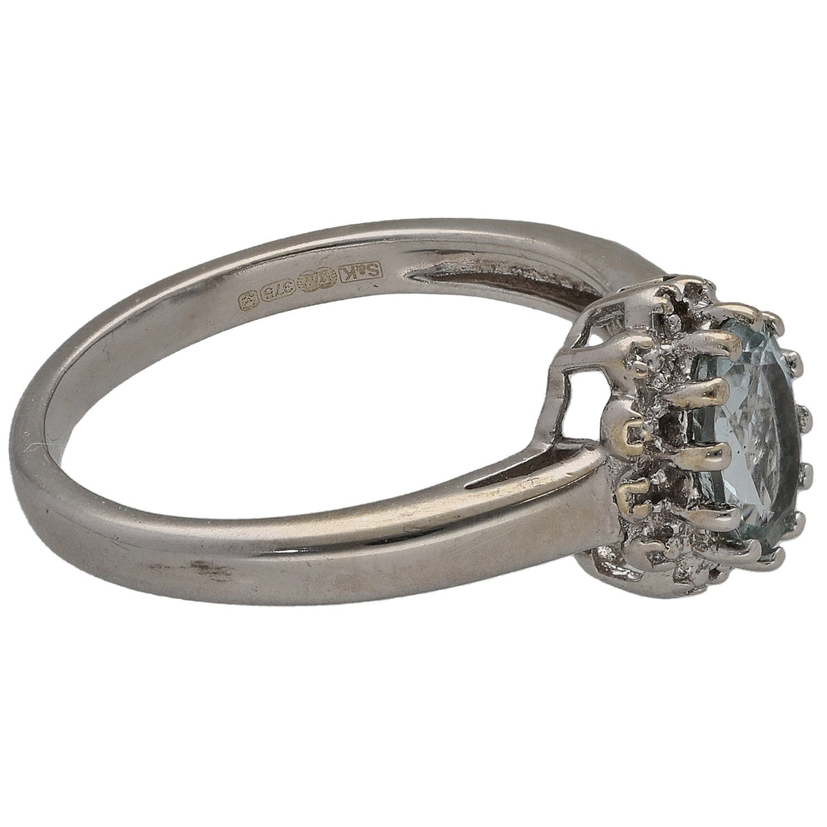 White gold ring with side view of aquamarine center stone and round diamond halo setting