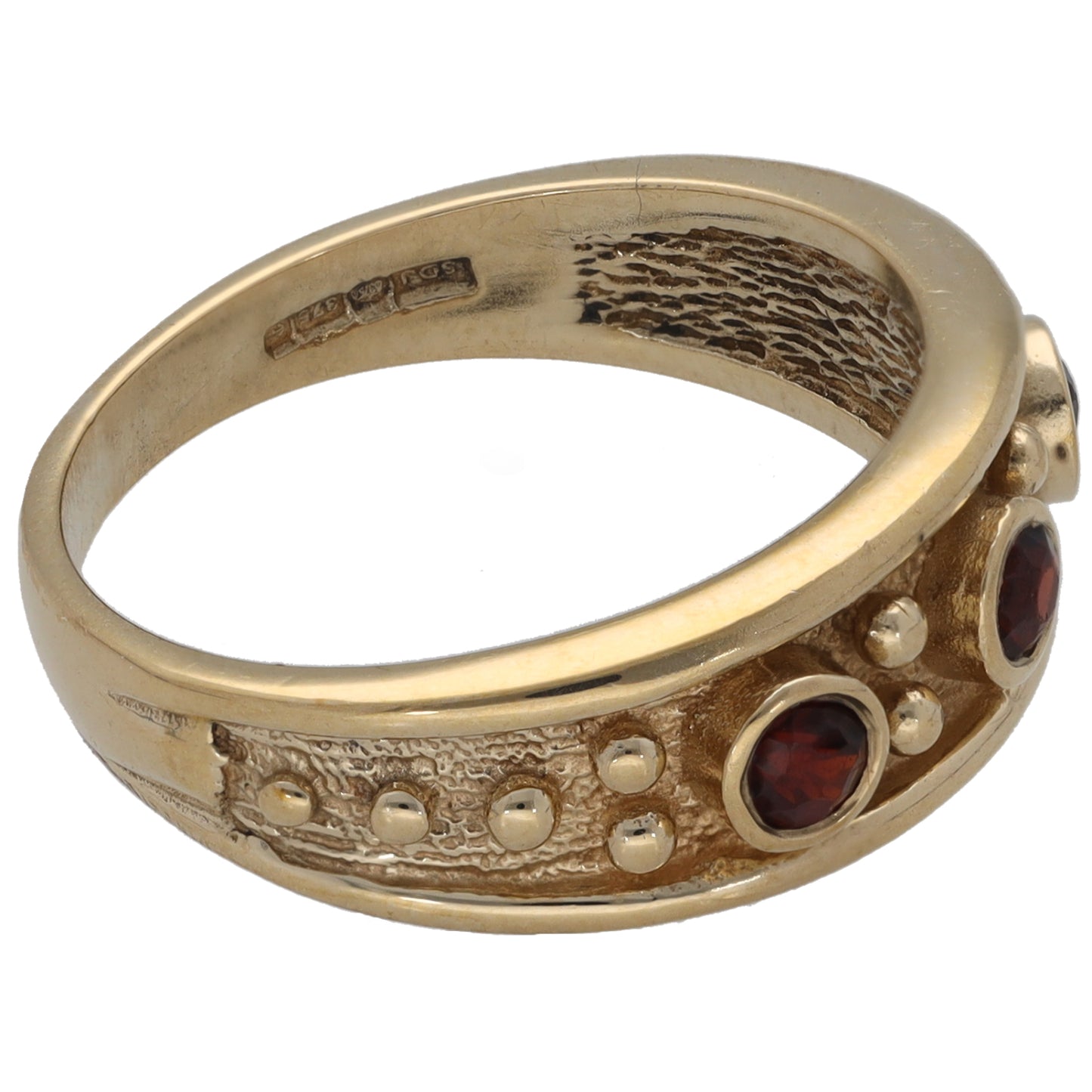 Gold ring with textured band and three red garnet stones in round settings