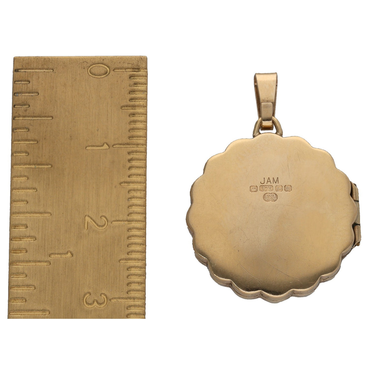 Gold locket pendant back with hallmarks; plain reverse shown beside ruler