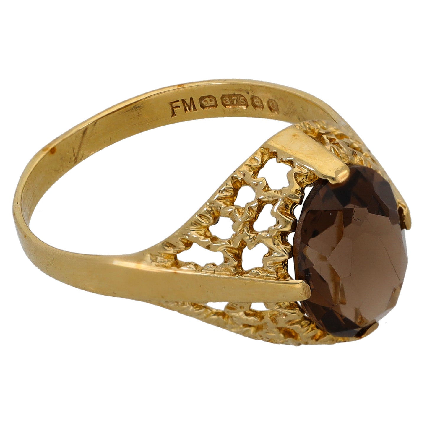 Gold ring with faceted dark gemstone, cutout lattice shoulders, engraved inside band