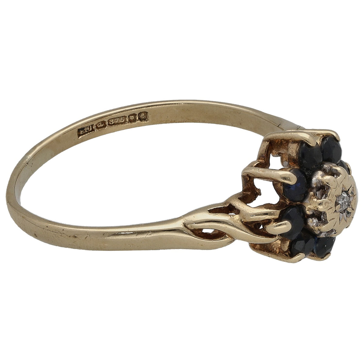 Gold ring side view with dark sapphire cluster and center round diamond, engraved band