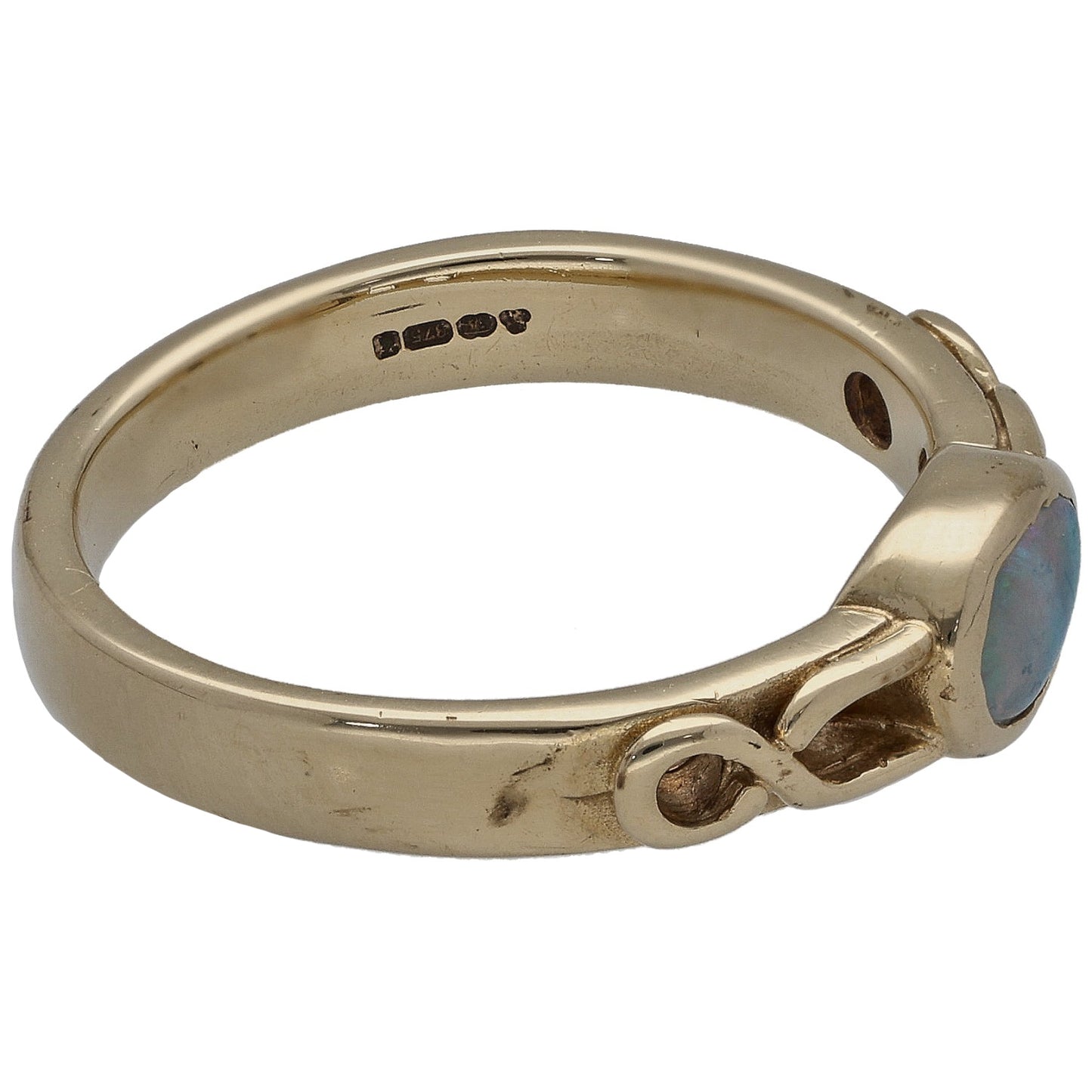 Gold opal single-stone ring side view with bezel setting and small engraved dots
