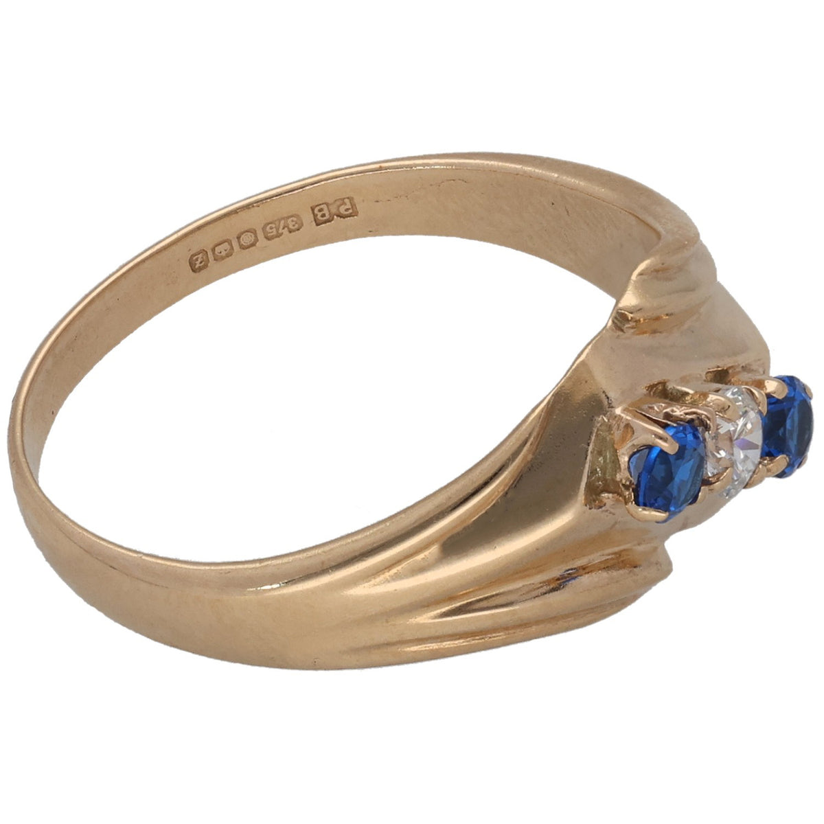 Gold-tone three-stone ring angled view, blue stones with center clear stone