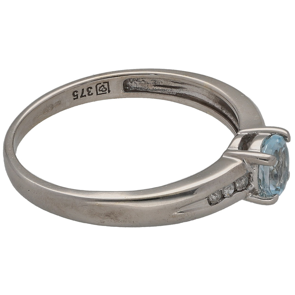Gold-toned ring side view with blue gemstone set in prongs and small diamond accents