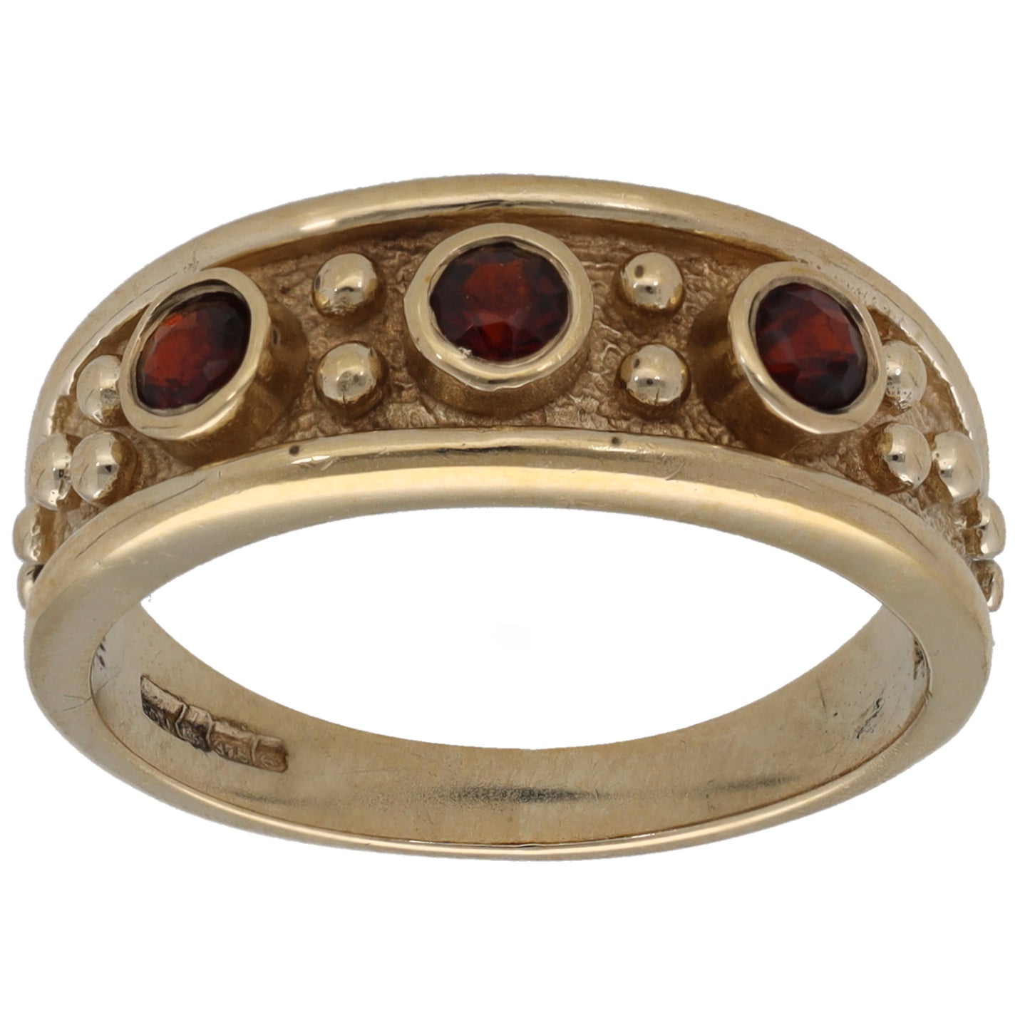 Three-stone gold ring with red garnet gemstones in bezel settings
