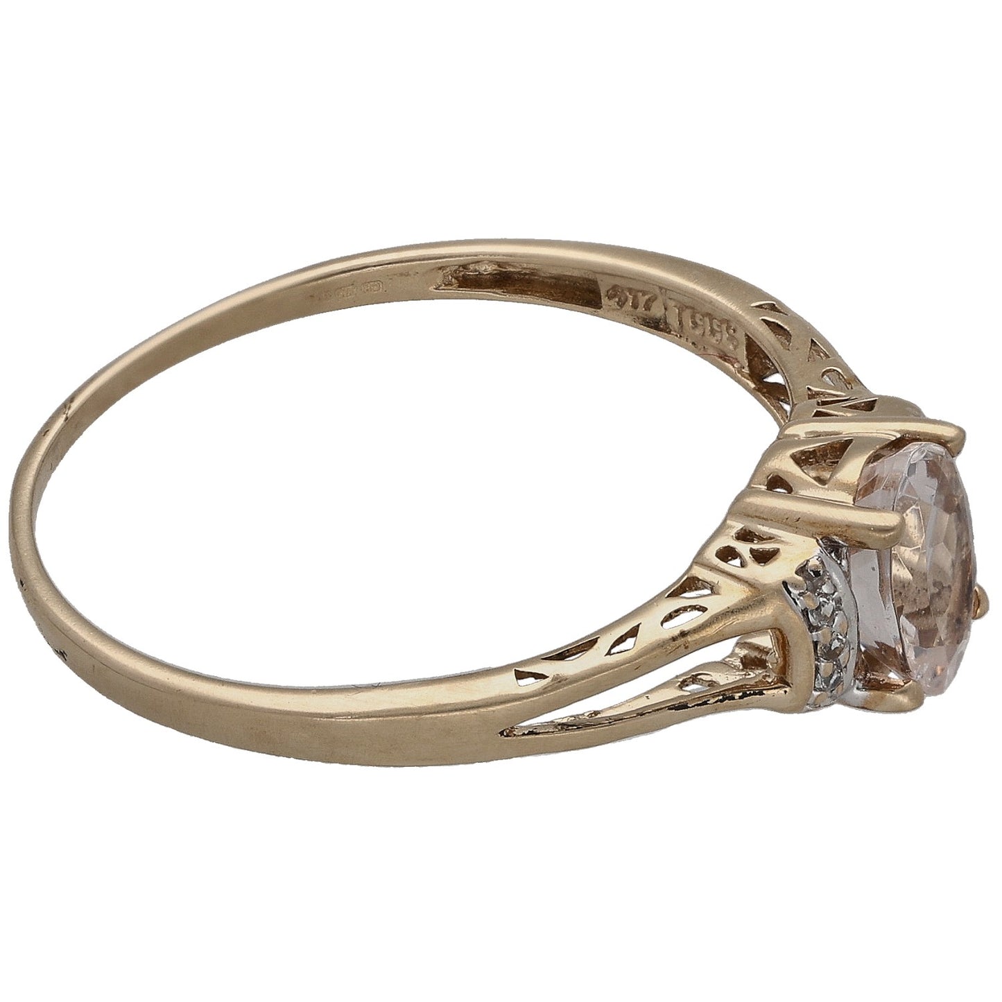 Gold-tone ring side view with oval clear centerpiece and decorative cutout band
