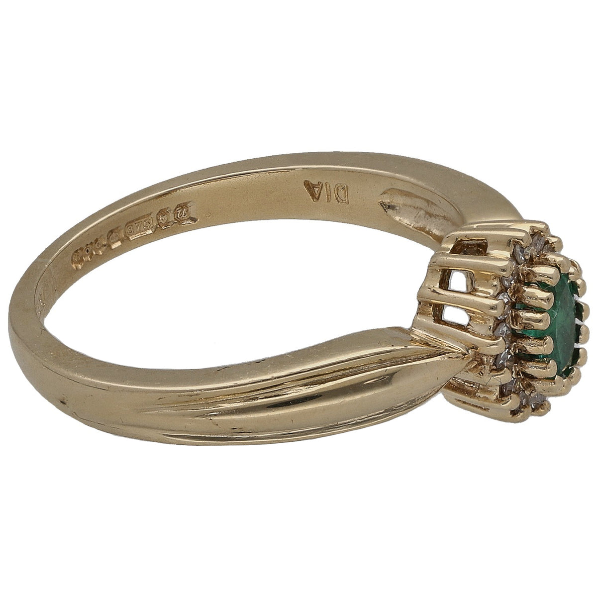 Gold ring side view: round emerald with diamond cluster on a sculpted band