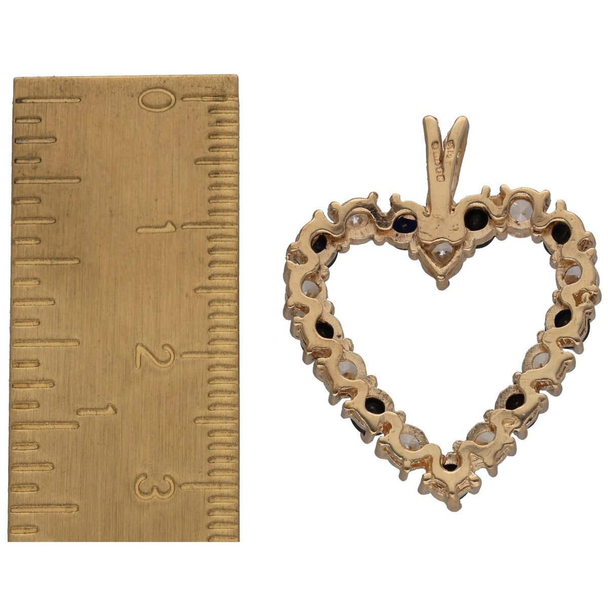 Heart pendant in gold with prong-set clear stones and dark gem border, top bail