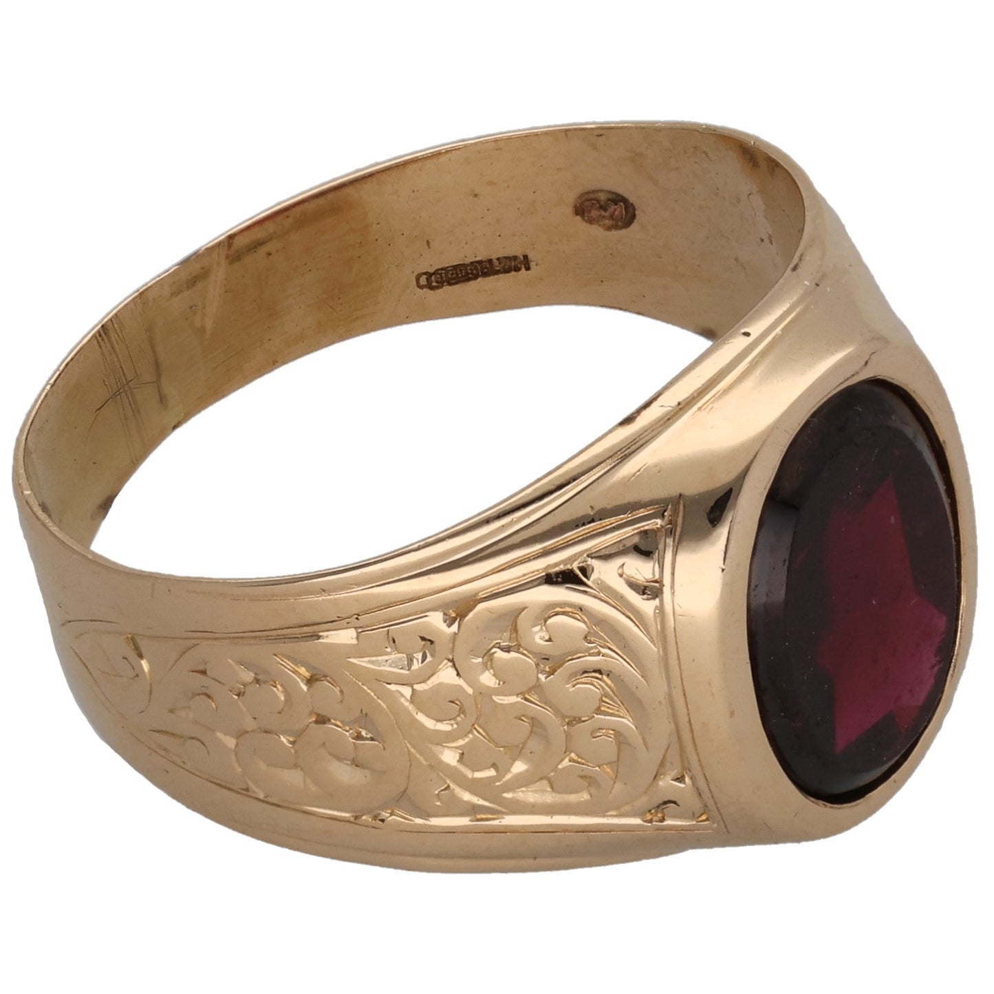 Gold signet ring side view with maroon oval gemstone and patterned engravings on band