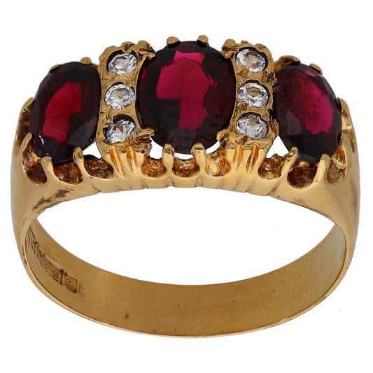 Gold cocktail ring with dark red and clear stones, ornate bezel setting
