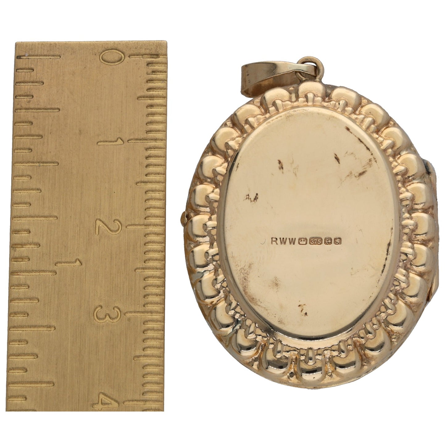 Gold oval locket pendant back with engraved markings and textured rim; small bail at top