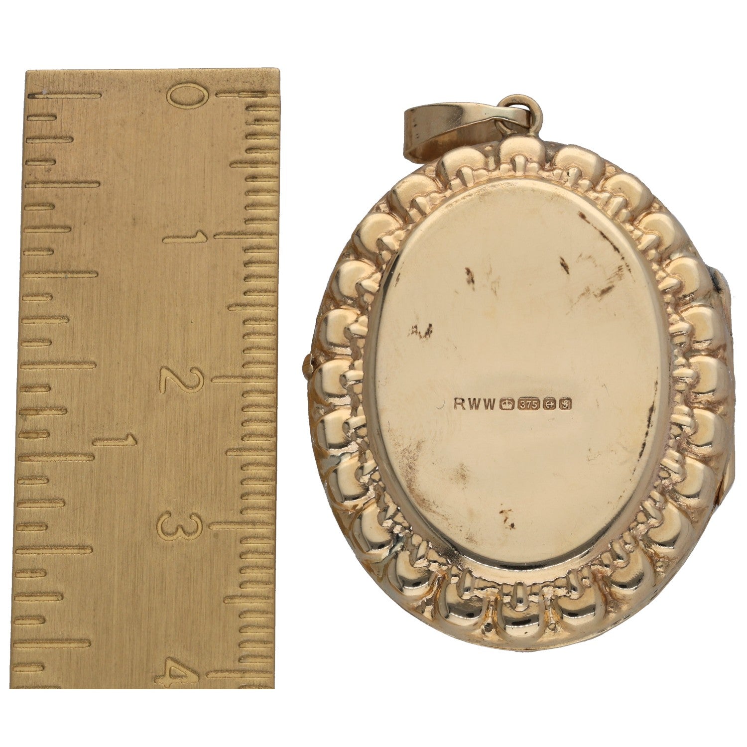 Gold oval locket pendant back with engraved markings and textured rim; small bail at top