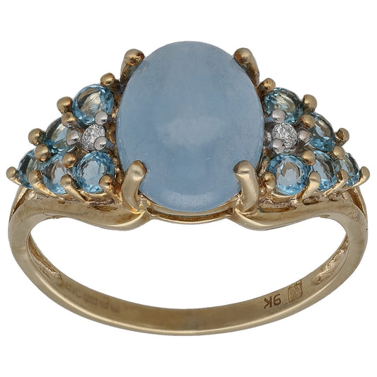 Gold cocktail ring with oval blue topaz center and diamond sparkle accents