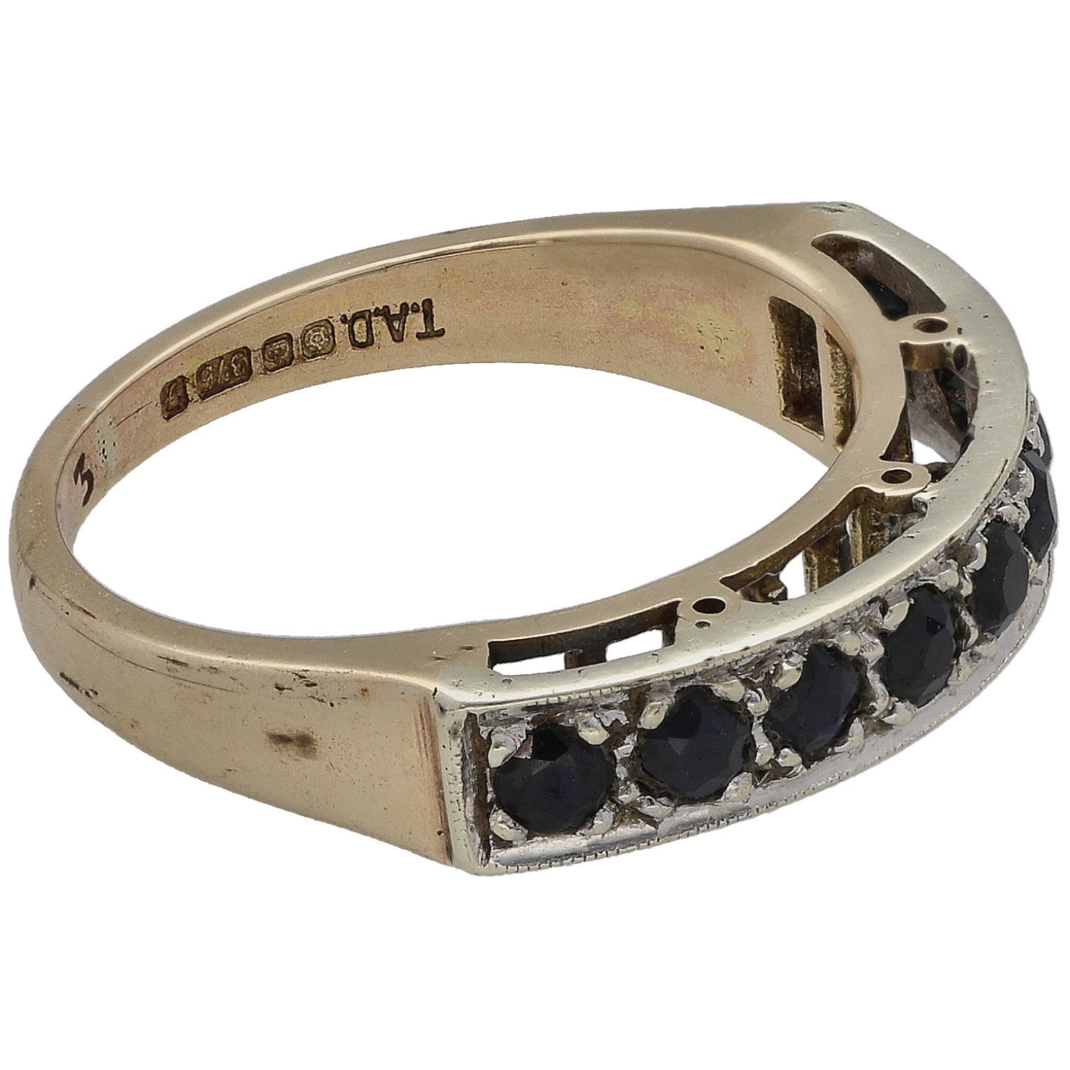 9ct gold half eternity ring with dark round gemstones along the side