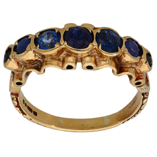 Gold cocktail ring with six dark blue sapphire gemstones in raised settings
