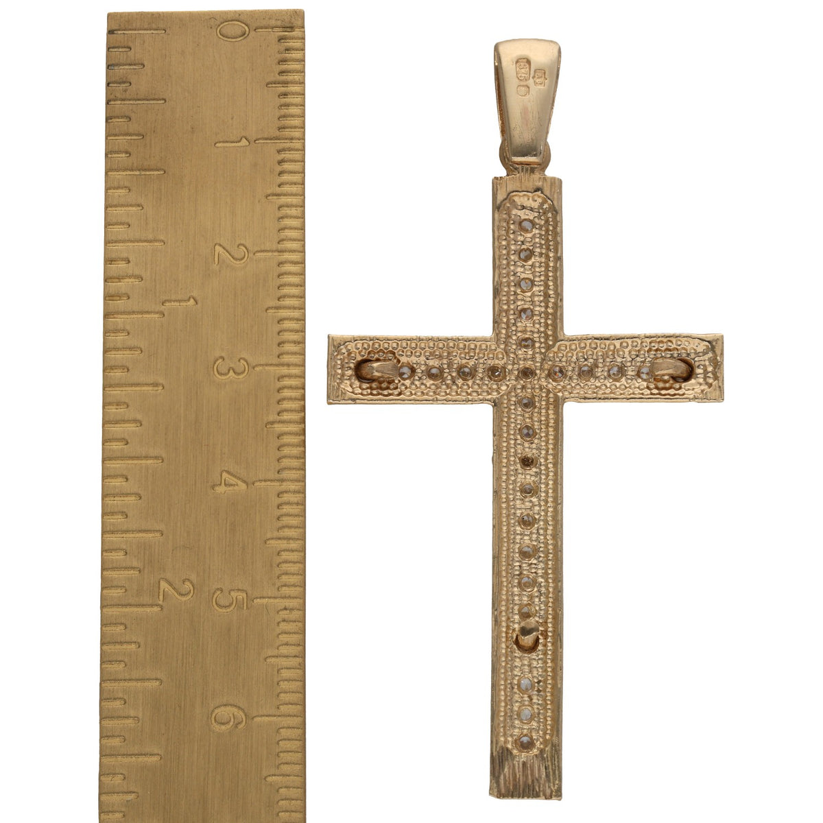 9ct gold crucifix pendant with CZ stones and a bail, shown beside a ruler