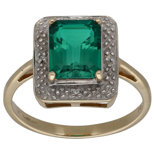 Gold cocktail ring with emerald-cut green stone and diamond halo, square setting