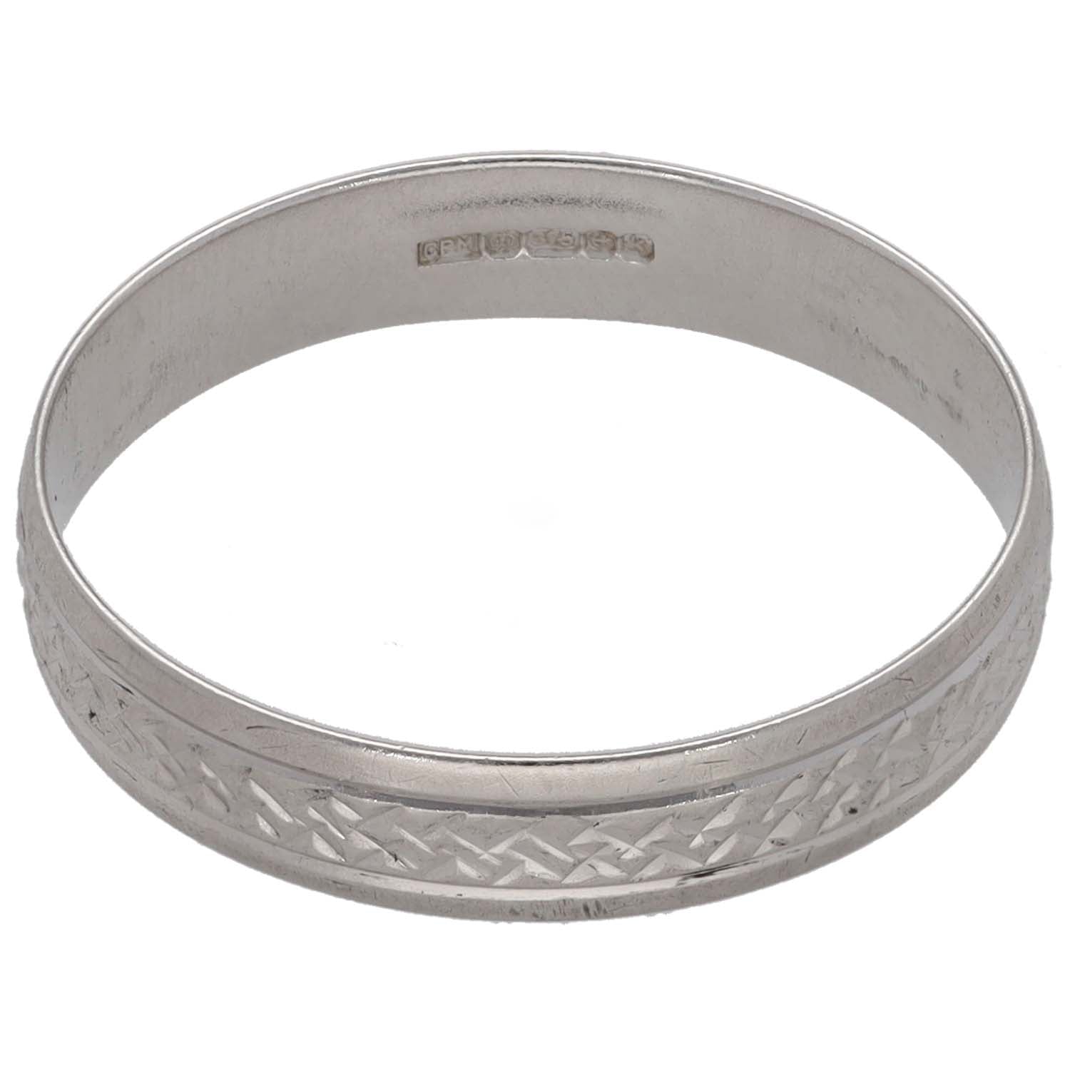 White gold wedding ring with diamond-cut pattern and stamped inner hallmark