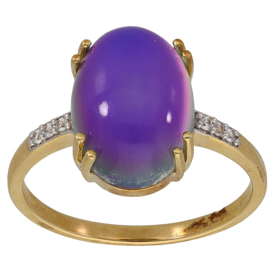 Gold-tone cocktail ring with oval purple cabochon and crystal side accents