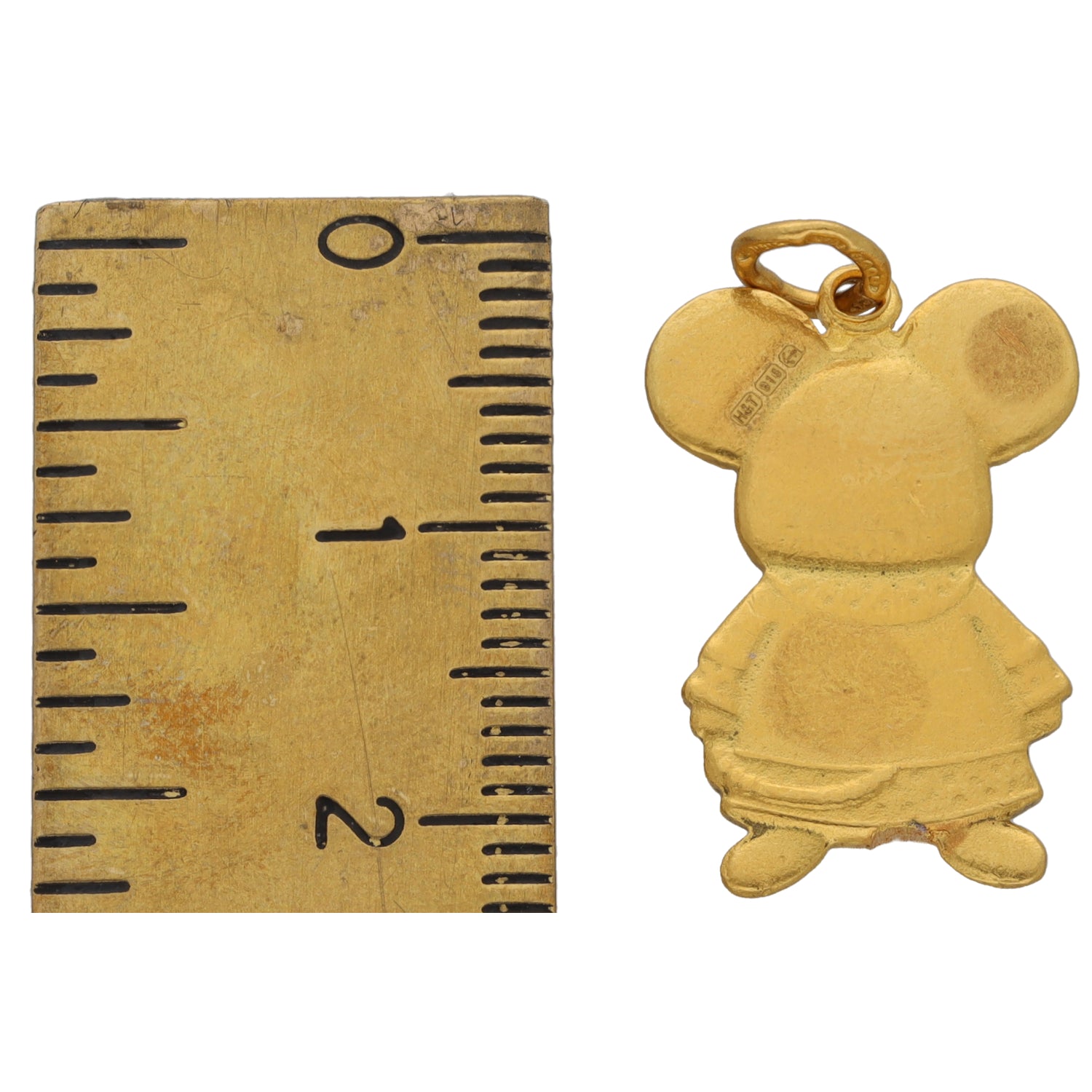 Gold clown/doll character pendant next to ruler for size scale