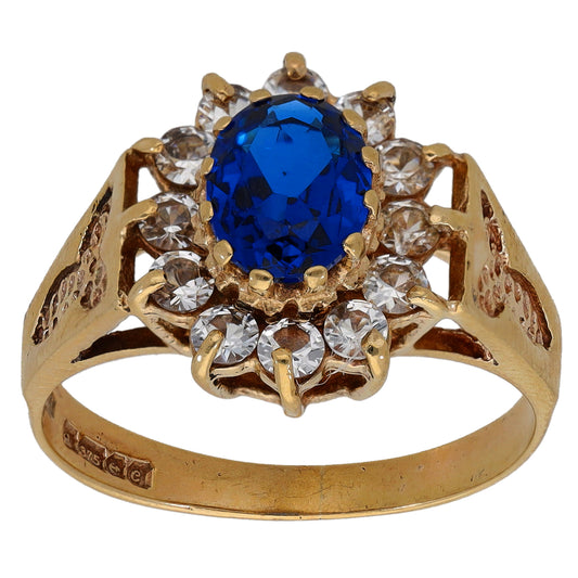 Gold-tone cocktail ring with oval blue center stone and clear crystal halo, size Q