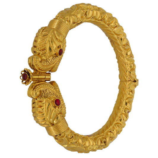 22ct Gold-tone hinged bangle with detailed carvings and red stones near clasp hinge