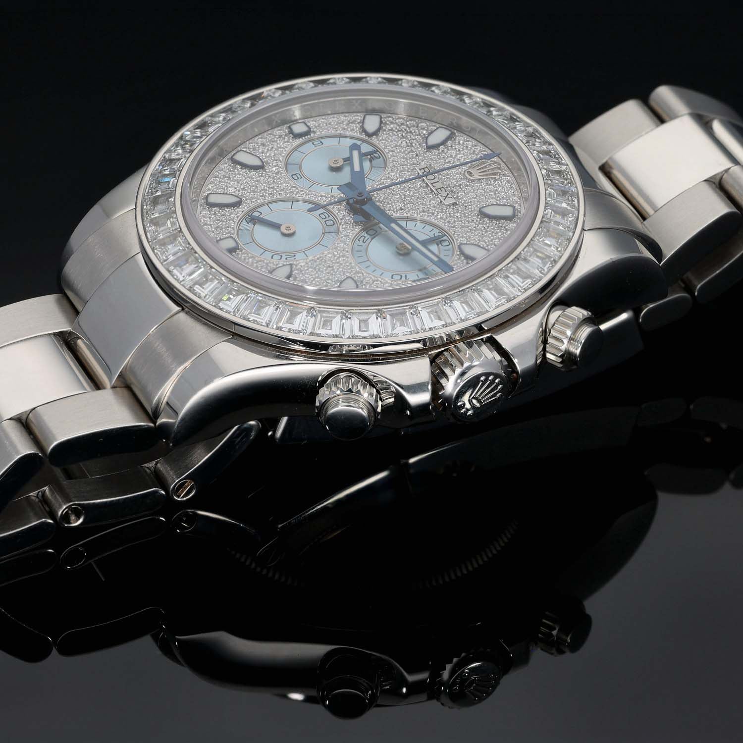 Platinum Rolex chronograph watch close-up with light blue dial and diamond bezel