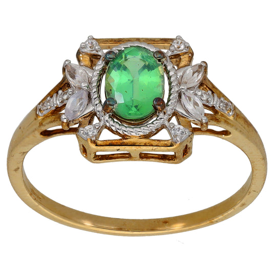 Gold cocktail ring with oval green center stone and clear gemstone accents