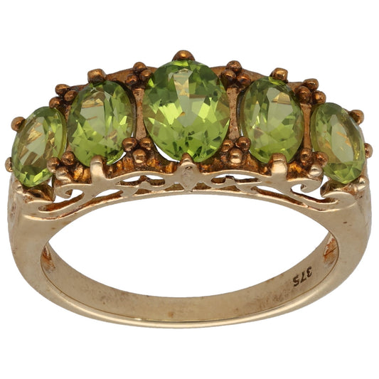 Gold ring with three oval green peridot stones in a half-eternity style