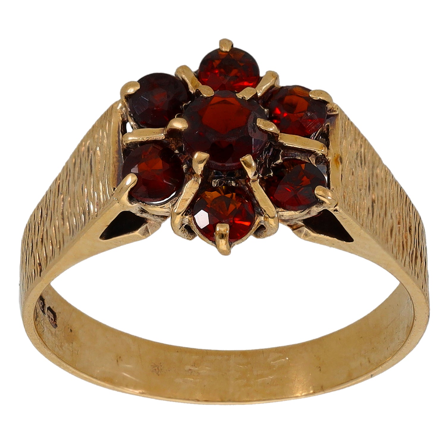 Gold cocktail ring top view, textured band with red gemstone cluster and gold star-like claws