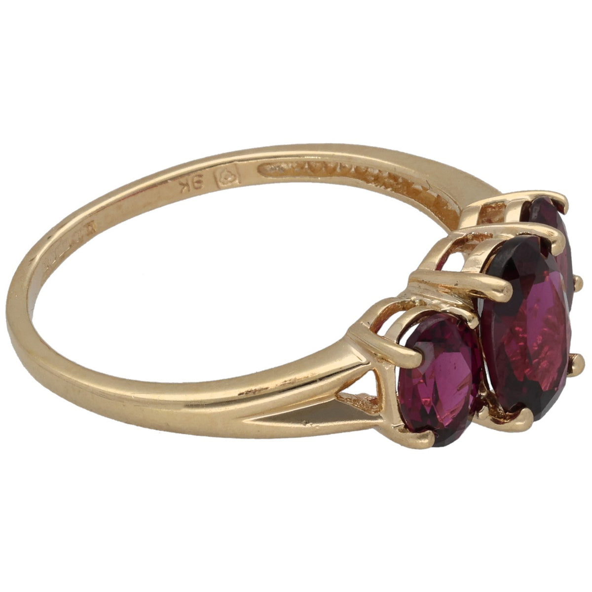 Gold three-stone ring with dark red garnet center and two side stones, prong-set