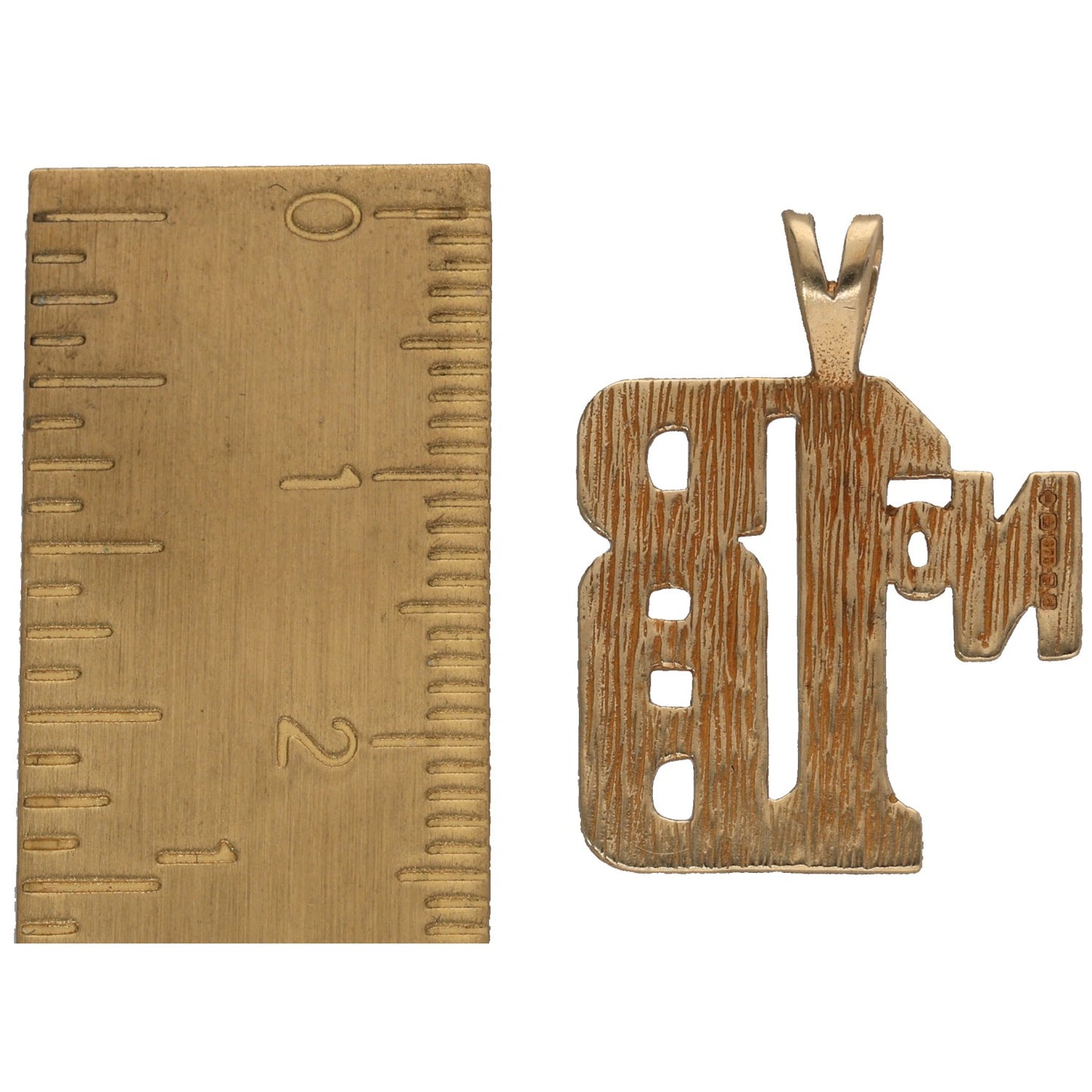 9ct gold message pendant with cutout letters, shown next to a ruler for size