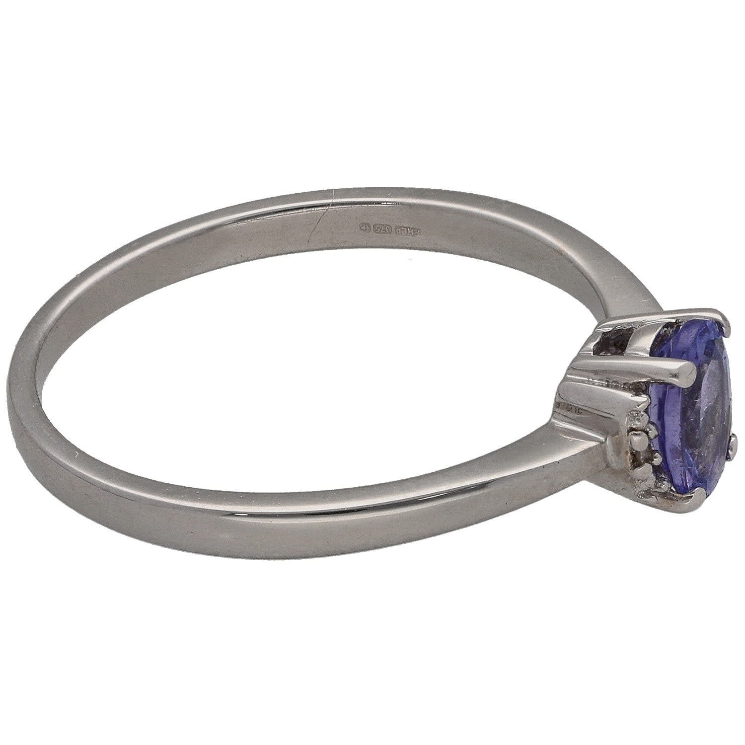 White gold tanzanite solitaire ring with side-mounted diamond accents, oval gemstone