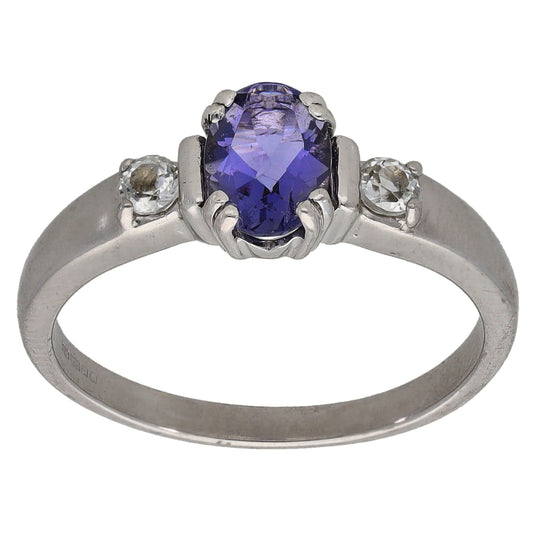 White gold tone ring with oval purple iolite-look center stone and two round side stones