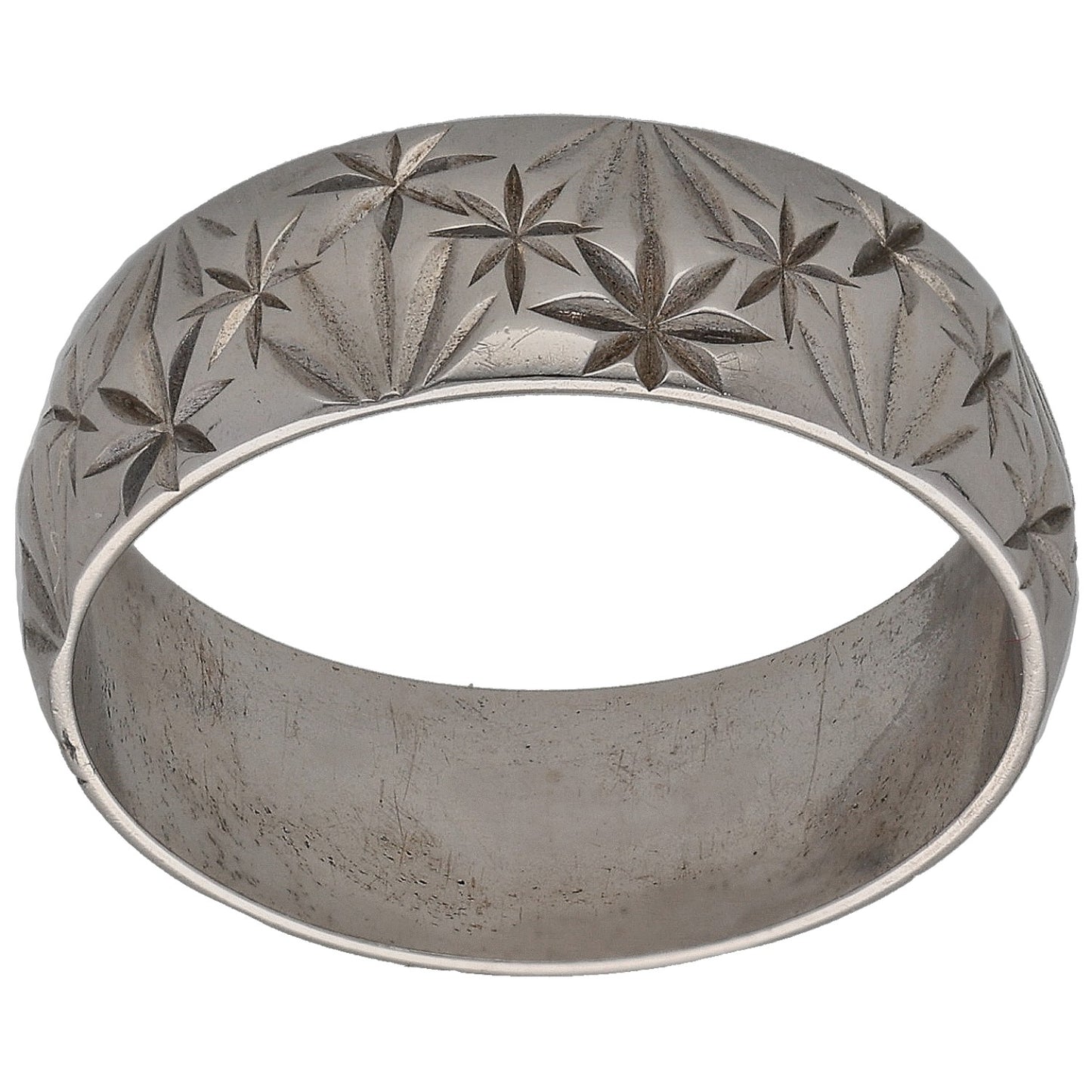 White gold wedding ring with carved star floral pattern across the band