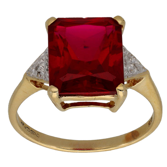 Gold ring with large red gemstone in square setting and diamond accents at shoulders