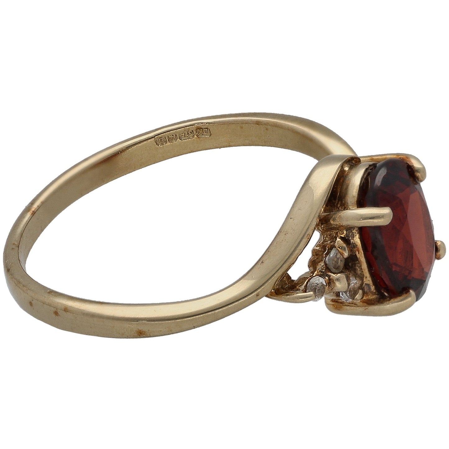 Gold cocktail ring side view, red garnet-style oval stone in bezel with small clear stones