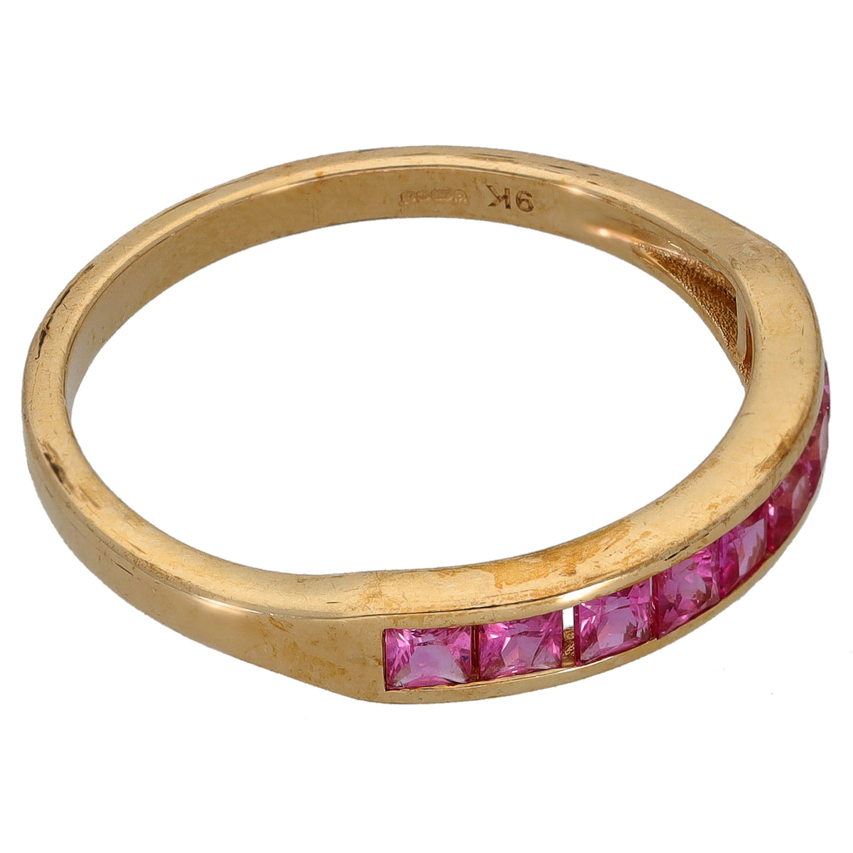 Gold half eternity ring with pink gemstone settings along the band