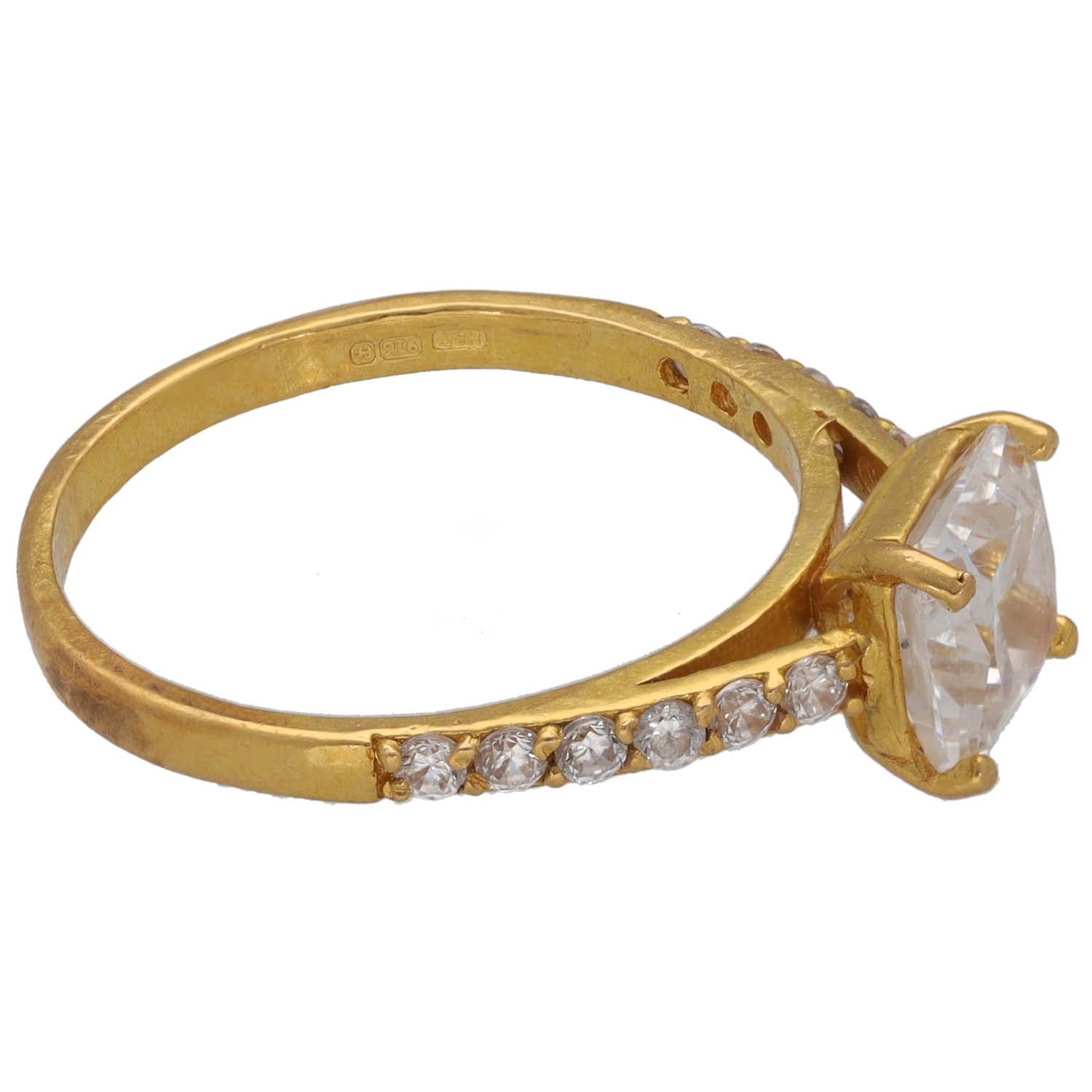 Gold CZ ring with large clear center stone, prong setting, and diamond-look pave band