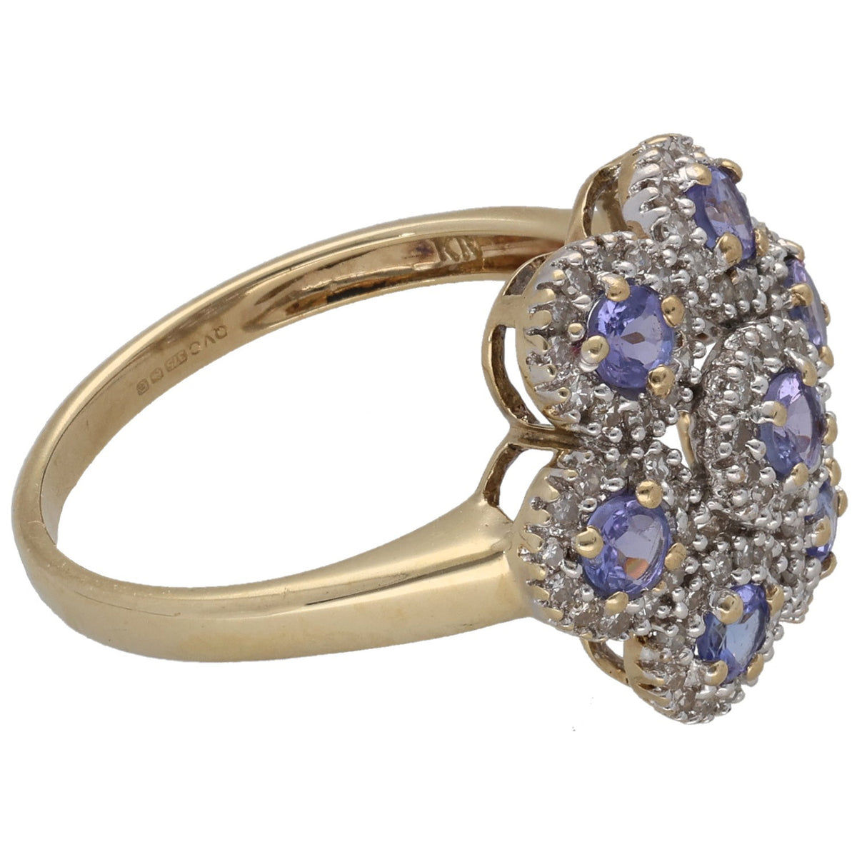 Gold cocktail ring with tanzanite-like oval center and blue stones in scalloped halo
