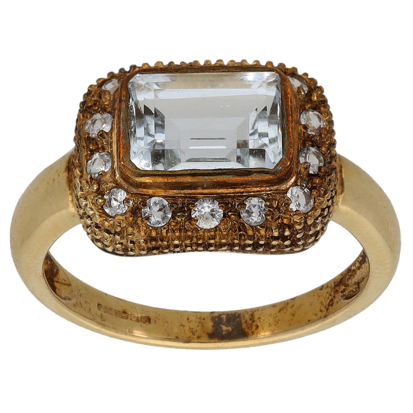 Gold cocktail ring with large rectangular clear center stone and round rhinestone accents