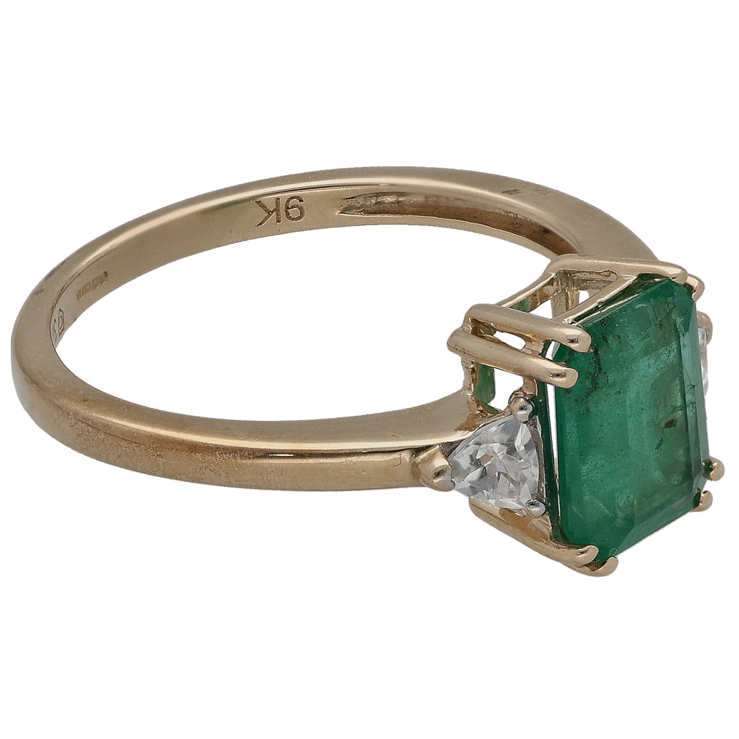 Gold three-stone ring angled view, square green center with clear side stones; engraved band
