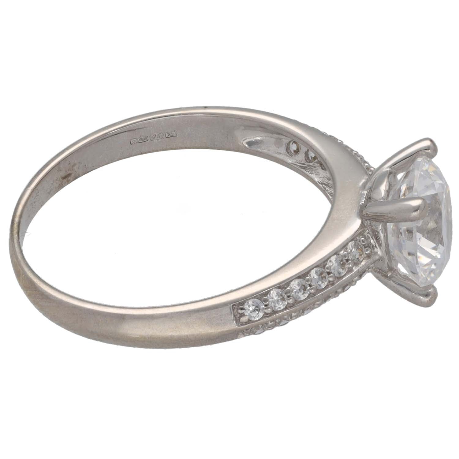 White gold ring with round cz center stone and accent stones along the band