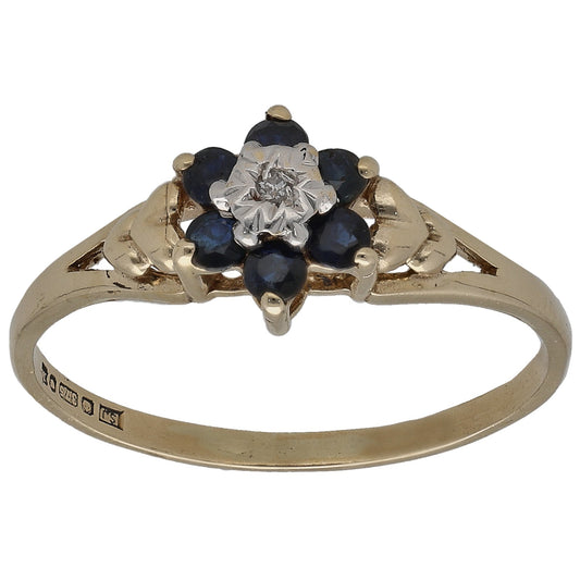 9ct gold cocktail ring with round diamond center and dark blue sapphire stones