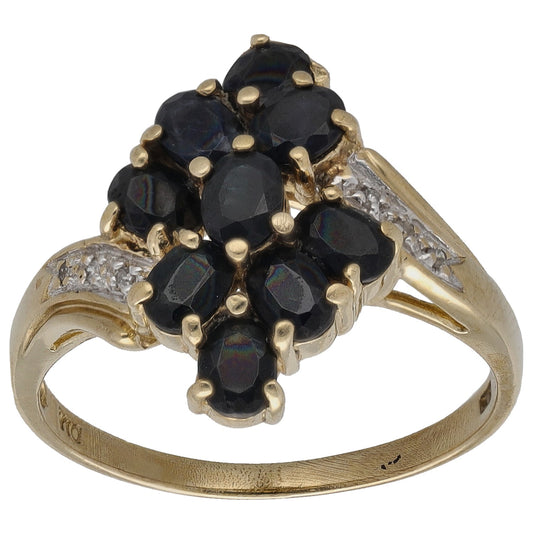 Gold cocktail ring with dark blue sapphire cluster and round diamonds, openwork setting