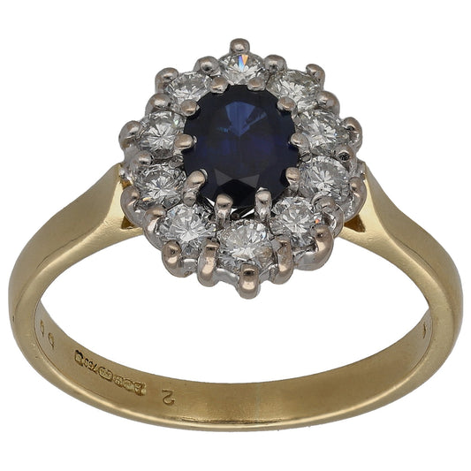 Gold cocktail ring with dark blue round sapphire center and diamond halo