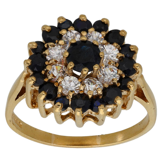 Gold-tone cluster cocktail ring with round clear stones and dark gemstones, prong set