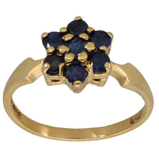 Gold sapphire cocktail ring with dark blue gemstone cluster and raised prongs